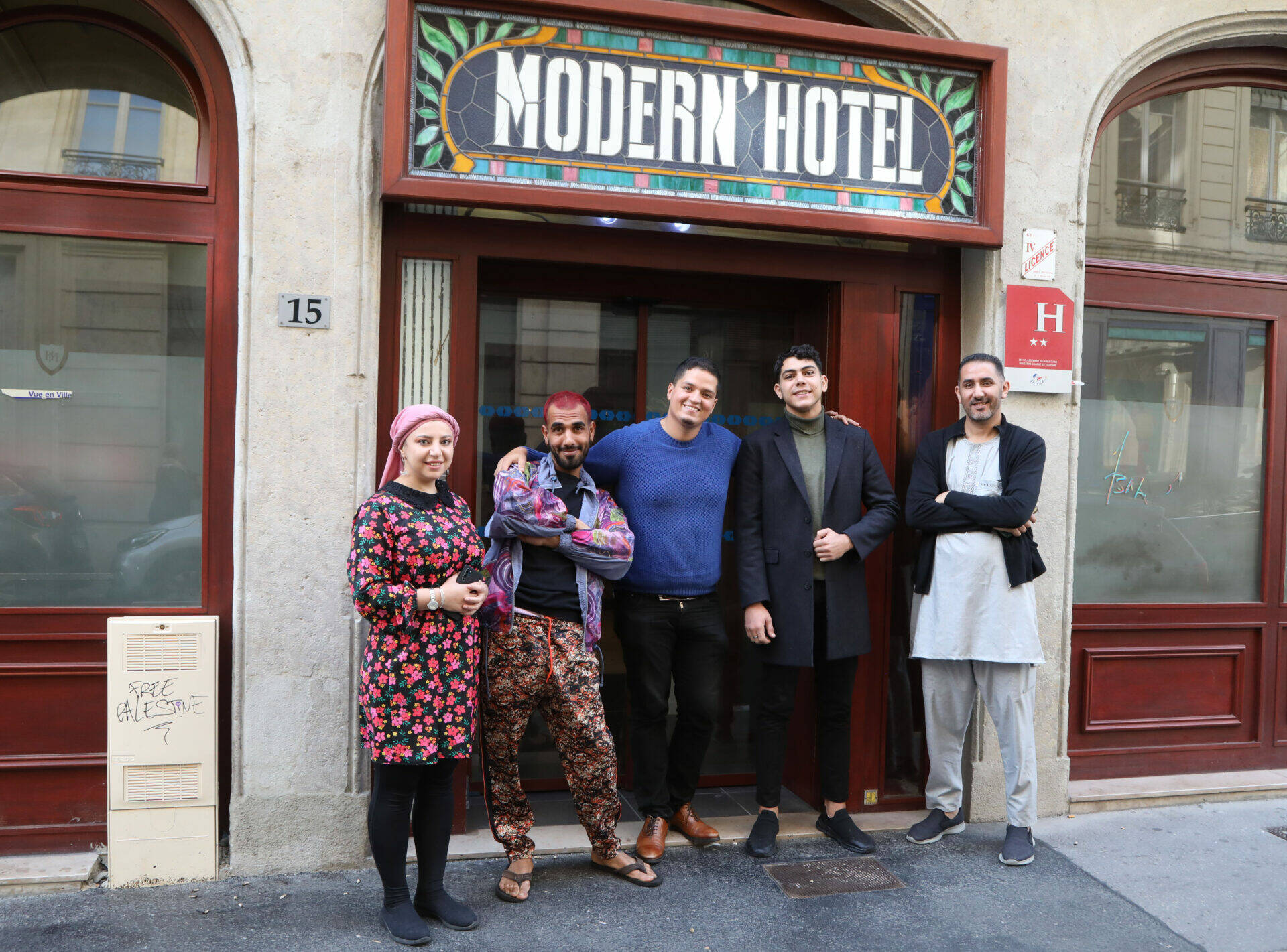 La colocation solidaire : Les colocataires devant l'entrée de leur nouveau domicile : l'Hôtel Moderne
