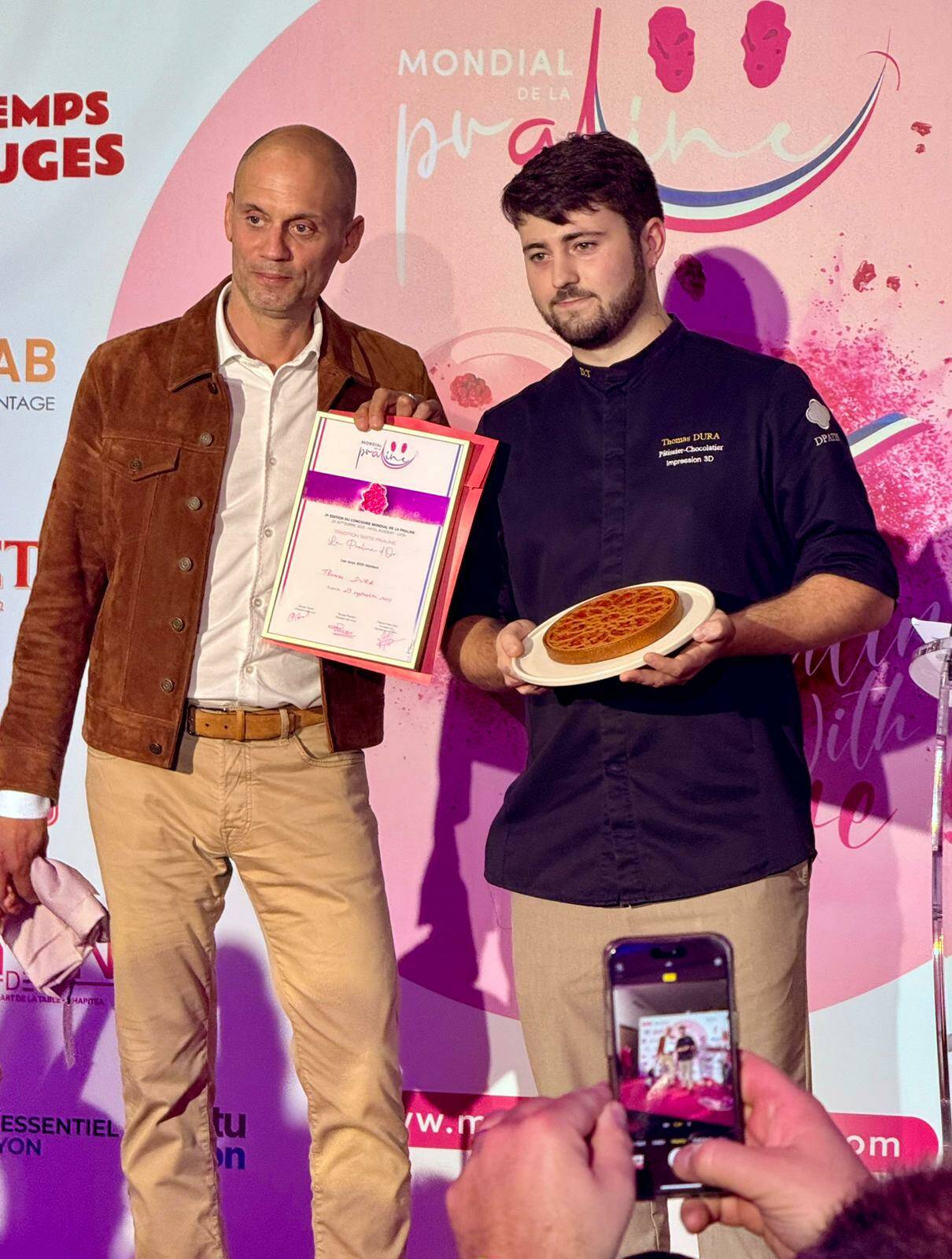 6e Sens Immobilier représenté par Nicolas GAGNEUX, remet la Praline d'Or pour la meilleure Tarte 2025 à Thomas Dura